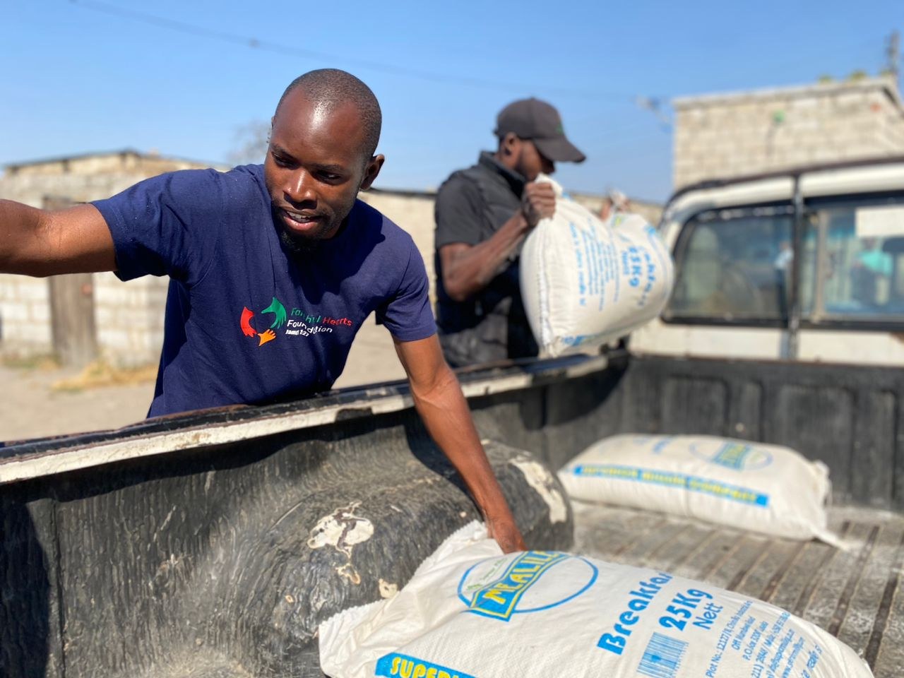 Volunteer loading bags of mealie meal for a community outreach